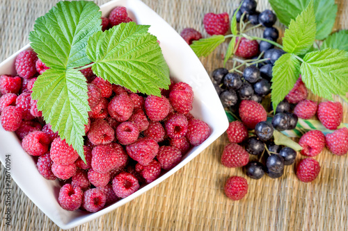 Raspberry and blackcurrant, chokeberry (aronia) - healthy organic fruit in bowl on table, healthy antioxidant in your eating - diet