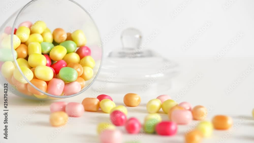 food, confectionery and sweets eating concept - close up of scattered candy drops and jar on table food, confectionery and sweets eating concept - close up of scattered candy drops and jar on table