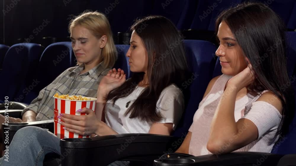 Young attractive woman looking angry when her friends grabbing popcorn ...