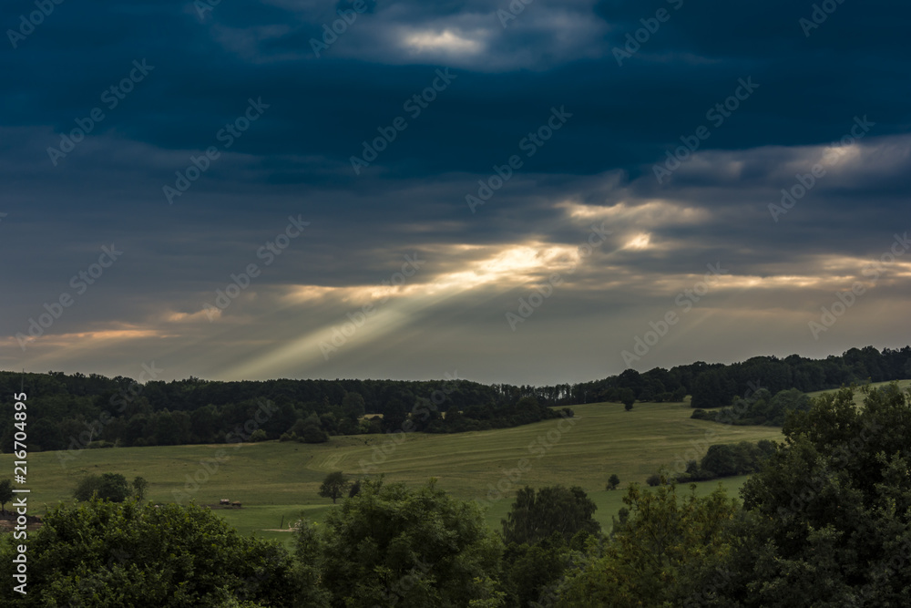 The landscape. Beam of sunlight. View from the rock hill to landscape. Amazing and dramatic clouds and sky.