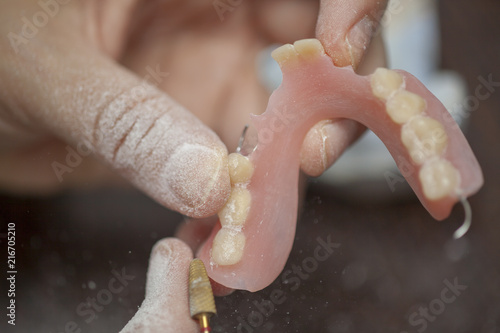 Dental technician work on denture prothesis in dental laboratory photo