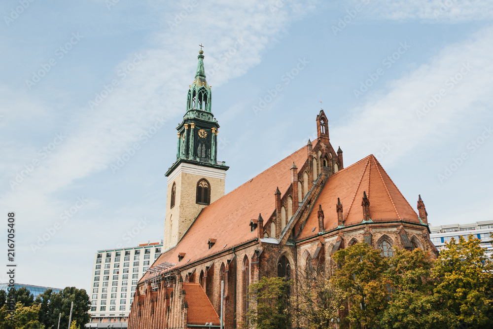 The Church of St. Mary in Berlin in Germany on the Alexanderplatz square against the blue sky in autumn. The Church of St. Mary in Berlin in Germany on the Alexanderplatz square against the blue sky in autumn.