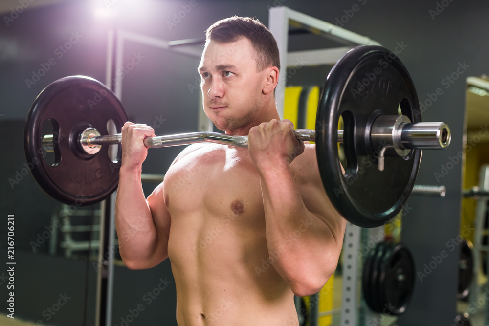 Powerful bodybuilder doing the exercises with barbell. Strength and motivation. Powerful bodybuilder doing the exercises with barbell. Strength and motivation.