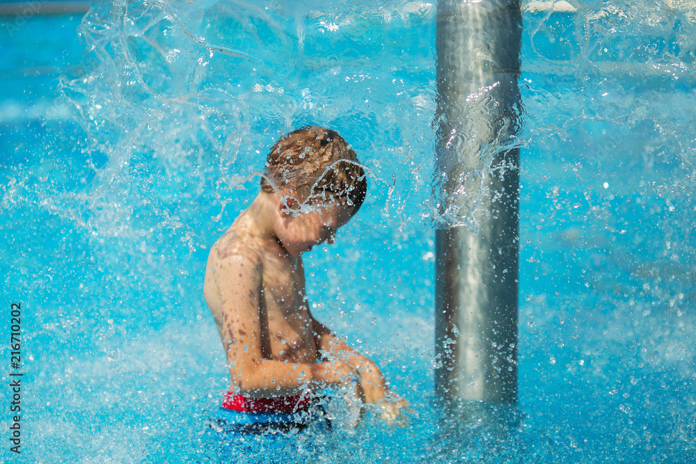 Φωτογραφία Happy kid playing in blue water of swimming pool on a tropical resort at the sea