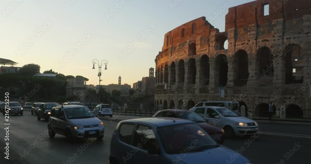 Lots of traffic infront of Colosseo, the colosseum ruins, in Italian capital city Rome, in Italy, on a sunny autumn evening Lots of traffic infront of Colosseo, the colosseum ruins, in Italian capital city Rome, in Italy, on a sunny autumn evening