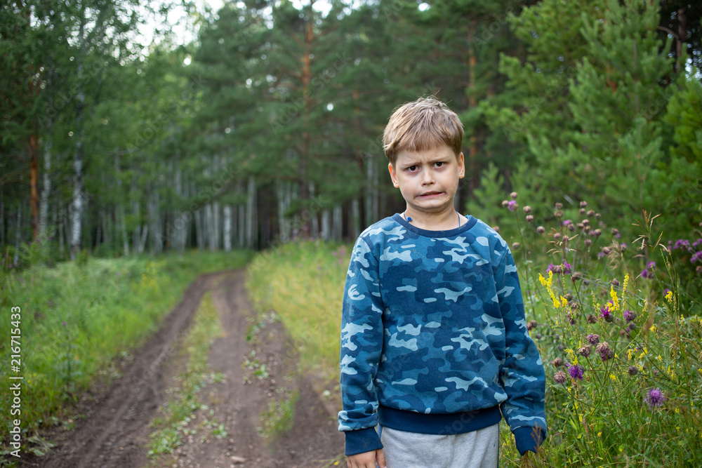 The child makes a terrible face in the woods