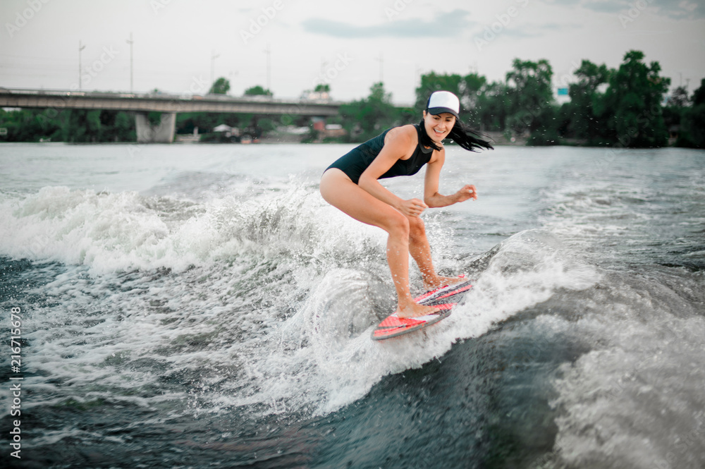 Young active girl riding on the wakesurf on the bending knees Young active girl riding on the wakesurf on the bending knees