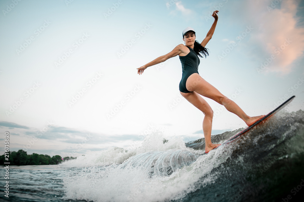 Rear view female wakesurfer riding on the wakesurf Rear view female wakesurfer riding on the wakesurf