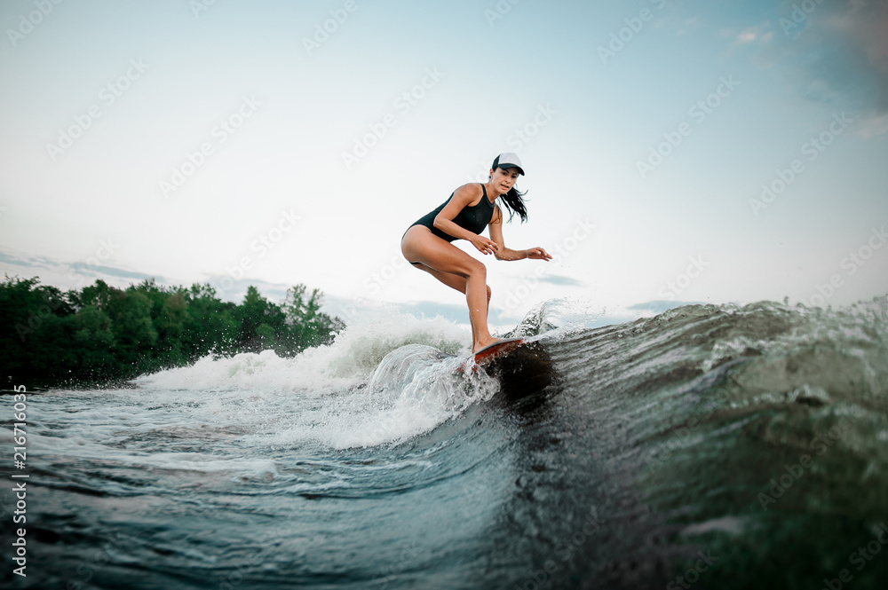 Fototapeta premium Young attractive woman riding on the orange surf