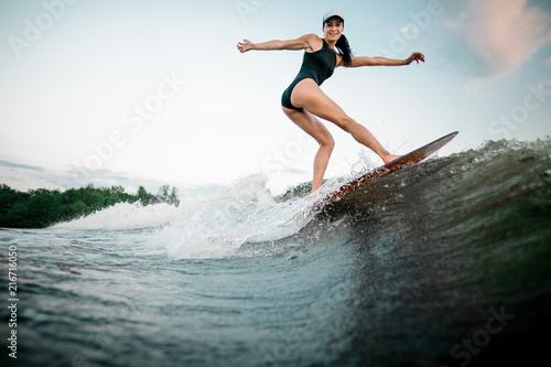 Rear view young active woman riding on the orange wakesurf © fesenko