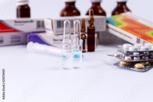 Ampoules on the background of packs with medicines. Medical concept