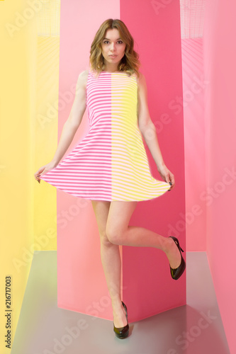 Obraz na plátně a girl in a dress striped in halves pink and yellow