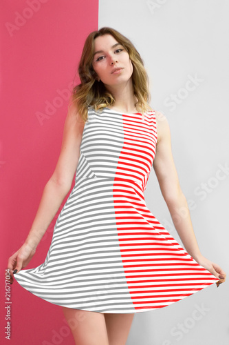Fototapeta a girl in a dress striped in half pink and gray