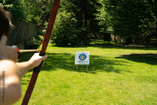 Bogenschütze schiesst Pfeil auf Zielscheibe