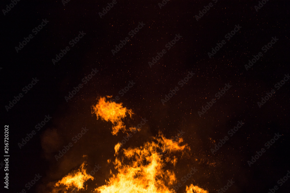 Fire flames with sparks and ember on black background