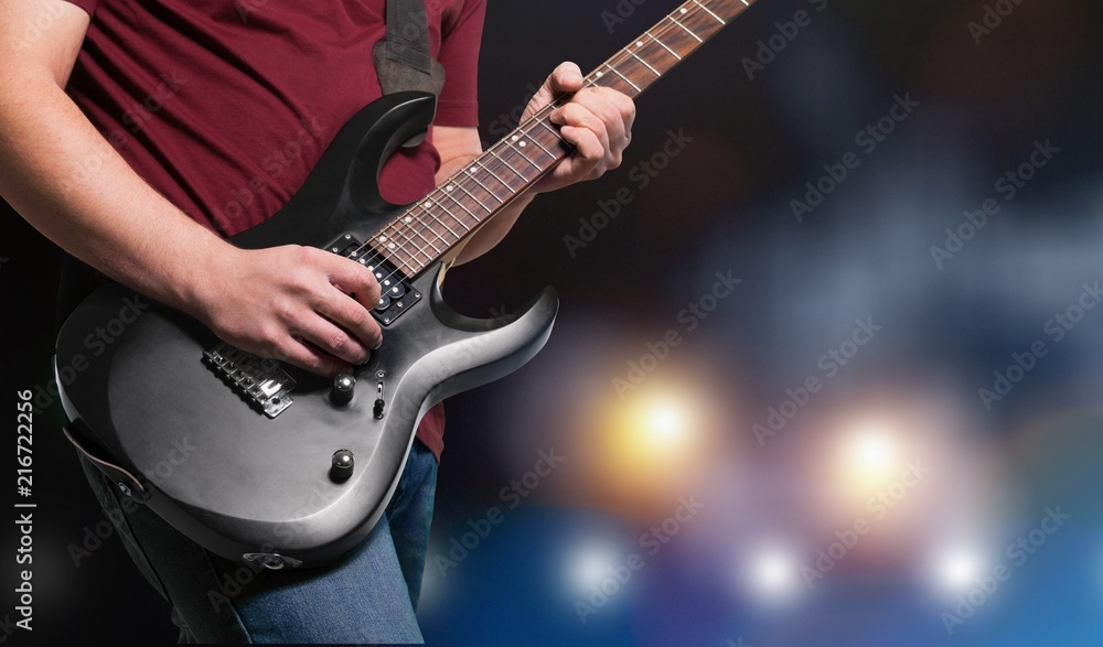 Male Guitarist playing music on dark background Male Guitarist playing music on dark background