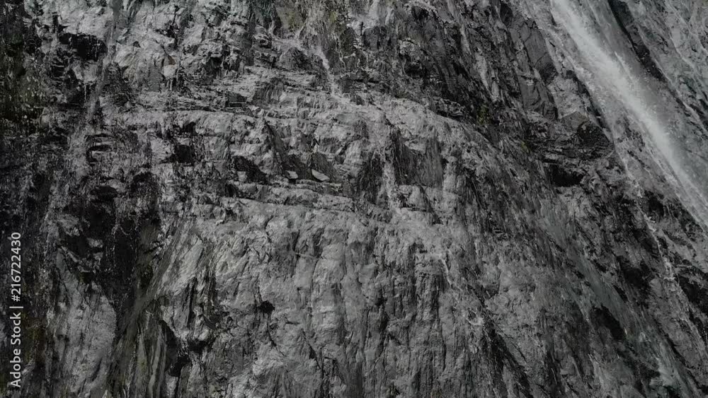 Tracking and top shot Air shot from a stream of water splashing waterfall on a rock wall in the Caucasus Mountains. Around the jet of the waterfall Tracking and top shot Air shot from a stream of water splashing waterfall on a rock wall in the Caucasus Mountains. Around the jet of the waterfall