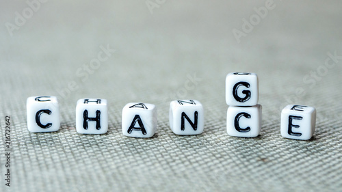 Changing white cubes with word "change" to "chance" on grey background