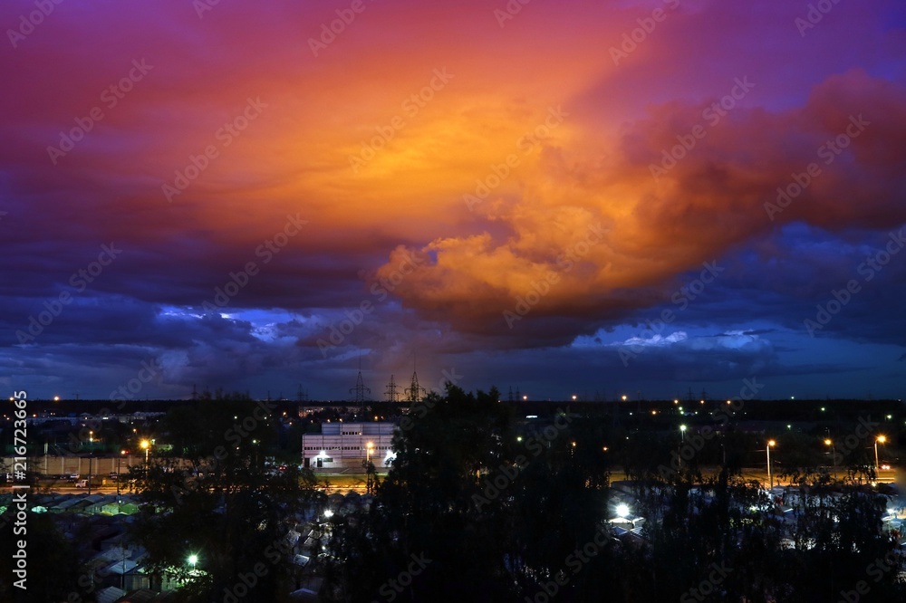 Fototapeta premium The sky at night with bright red clouds in the rays of the sun.
