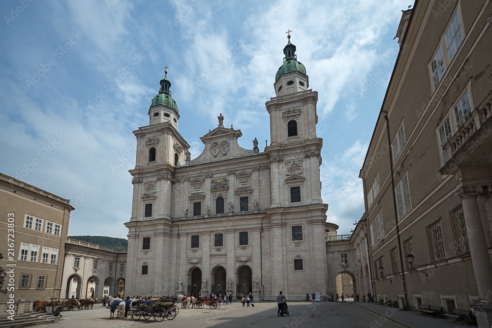 Salzburg, Austria, May, 4, 2018. Tourists walk in front of Salzburg cathedral. The cathedral if one of mein travel destinations of the city