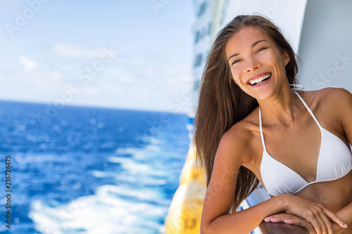 Cruise ship Caribbean travel vacation Asian woman tourist in bikini enjoying deck on troipcal holiday. Smiling happy girl having fun on boat. Portrait lifestyle. © Maridav