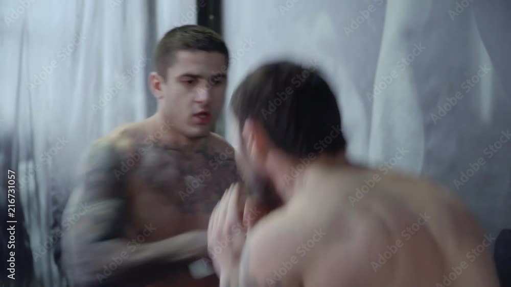 Two boxers with tattoos box in the gym Two boxers with tattoos box in the gym