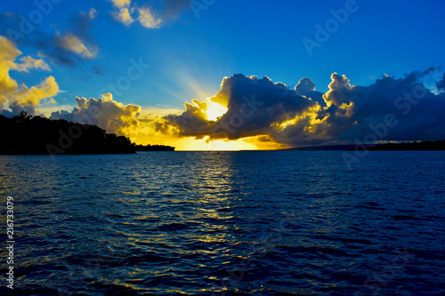 A sunset over the water in the clouds.