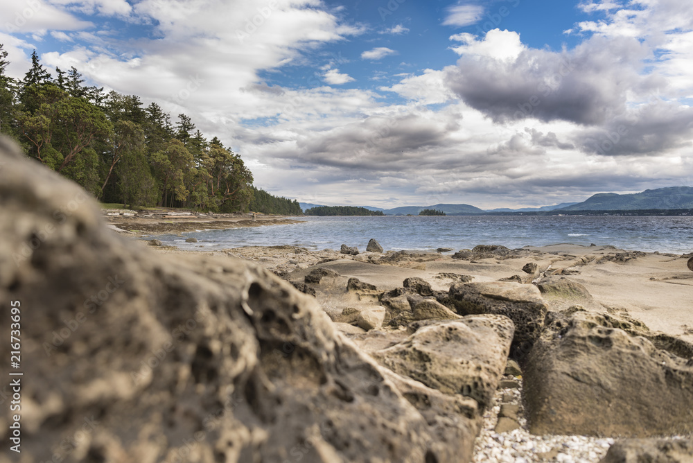 Rocky beach on the scenic ocean Canada mountains with white clouds
