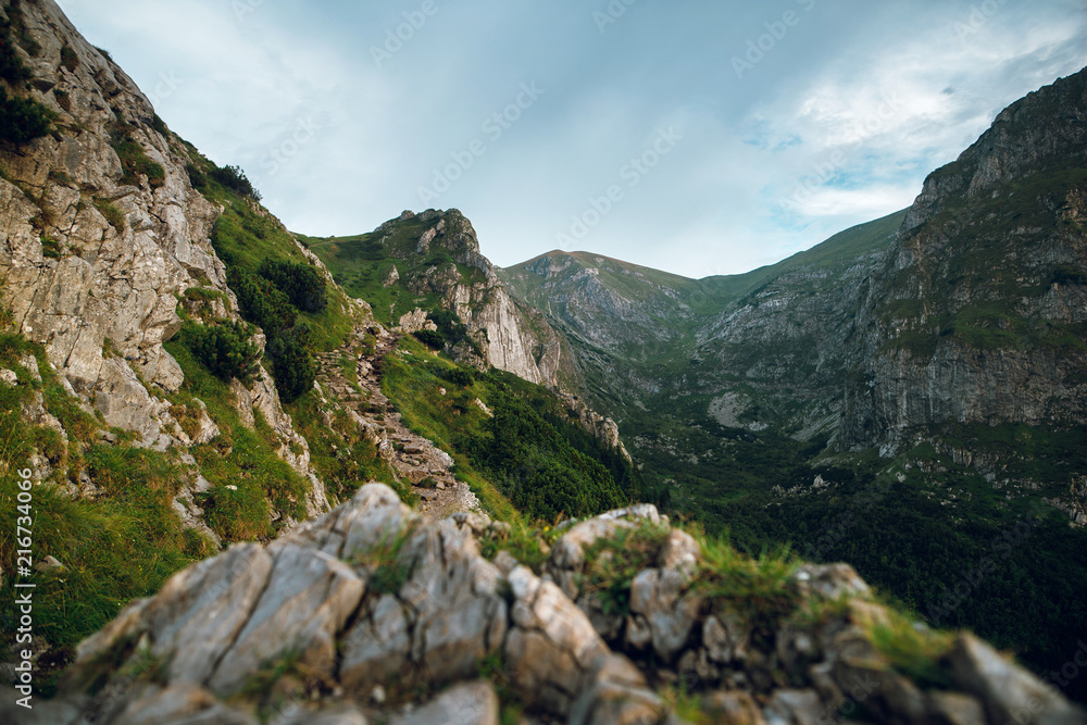 Scenic view of beautiful rocky mountains and cliffs with green grass and hills. Rysy mountains, High Tatry, Poland, Slovakia. Marine eye