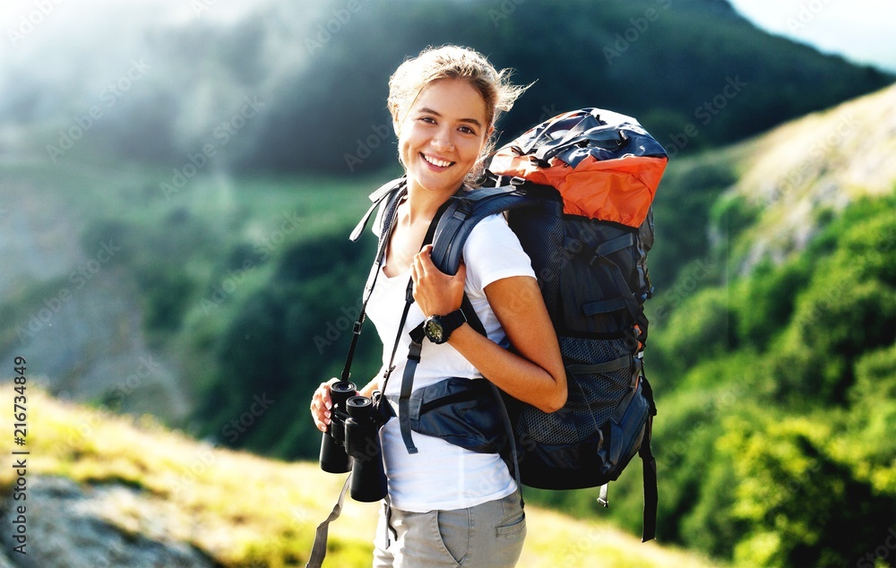 Woman with backpack trekking through the wilderness - obrazy, fototapety, plakaty 