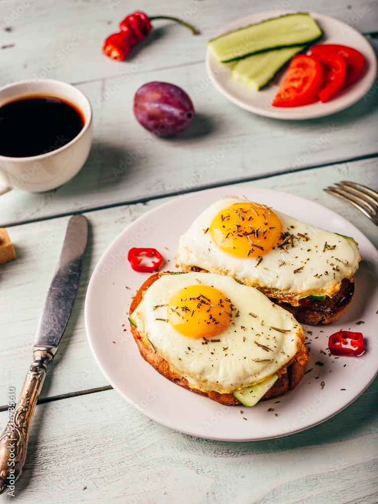 Toasts with vegetables and fried egg and cup of coffee Toasts with vegetables and fried egg and cup of coffee