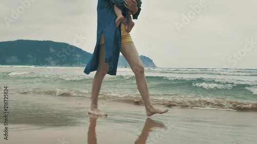 4 k beautifull young girl, mother walking and taking time with her cute little baby, among the Cantabrian coast, in the bay of Atlantic ocean at cloudy morning