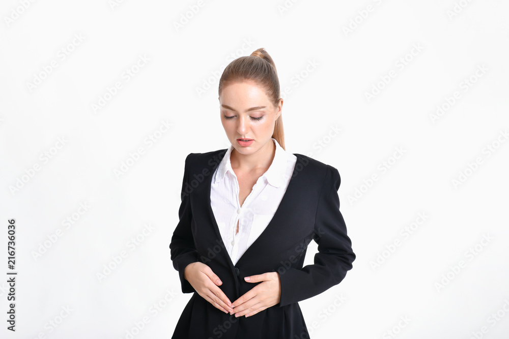 Business concept. Young businesswoman is suffering from severe stomach pain. Young businesswoman is on a white background. Business concept. Young businesswoman is suffering from severe stomach pain. Young businesswoman is on a white background.