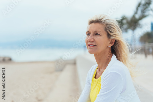 Thoughtful older woman on a seafront promenade #216736435