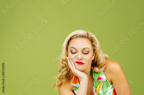 Canvas-taulu Portrait of a grumpy blonde woman, isolated on green studio background