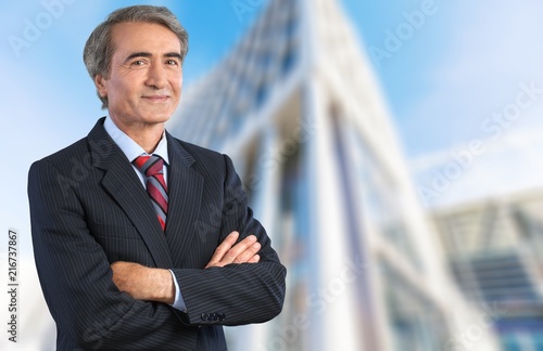 Mature confident Businessman on background