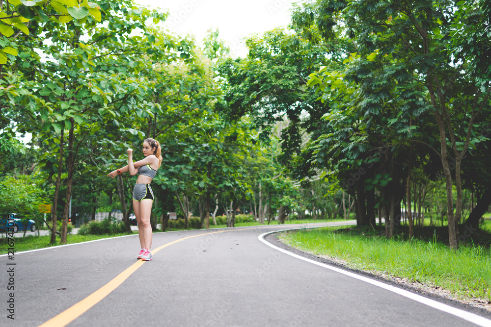 Pretty sporty woman jogging at park in sunrise light Pretty sporty woman jogging at park in sunrise light