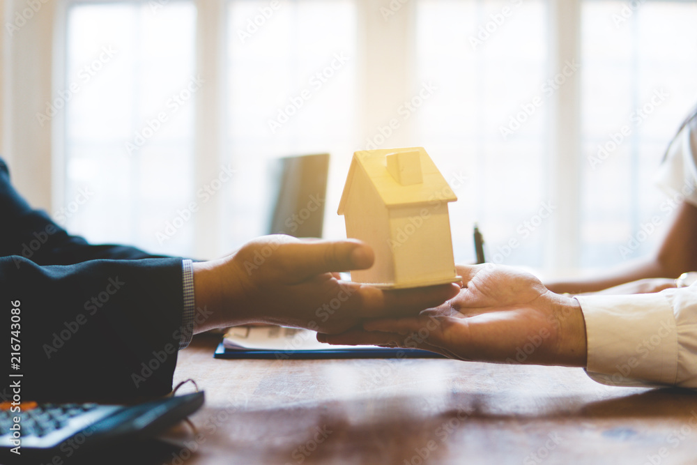 Broker giving keys of new house and handshaking with customer Broker giving keys of new house and handshaking with customer