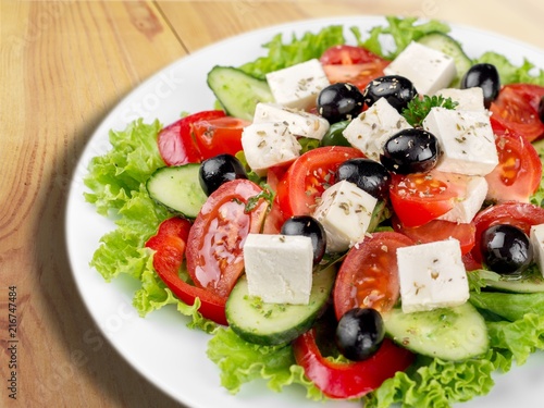 Greek salad with fresh vegetables on desk