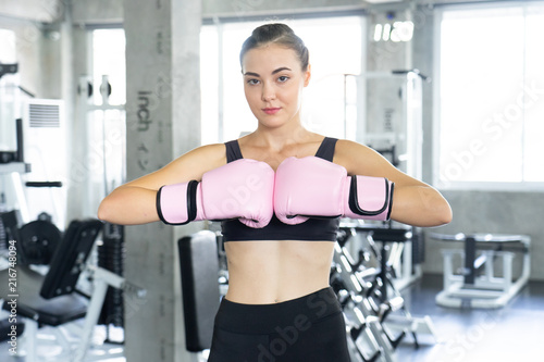 Boxing young beautiful woman exercises with pink glovw.She doing exercise and punching .