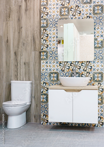 Modern spacious bathroom with bright tiles with toilet and sink.