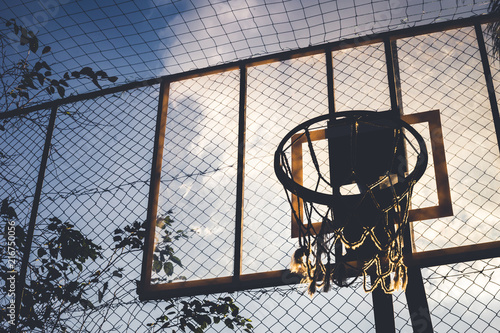 Side and bottom view from a basketball hoop in a daylight. Through this image we can see everything about sports, game, competition, teans, dayoff and much more.