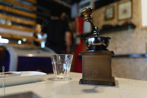 Hand crushing beans with coffee grinder