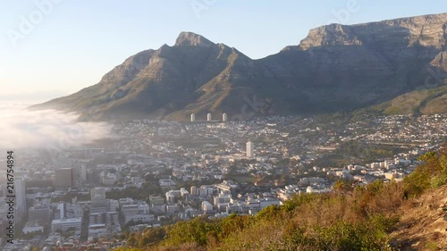 A beautiful scene from the hillside outside Cape Town as the sun rises with clouds covering part of the city.