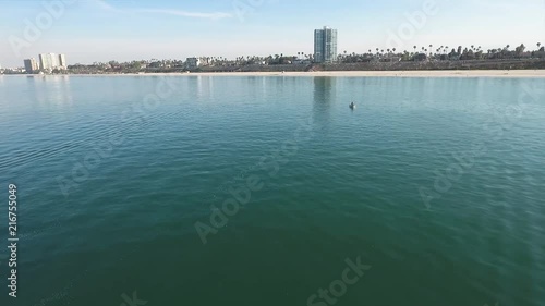 Wallpaper Mural fishing in the pacific ocean near Long Beach shores. fishing boat of men fishing and boat jetting through the water. blue aqua water perfect for spending the day at the beach. areal view of the ocean Torontodigital.ca