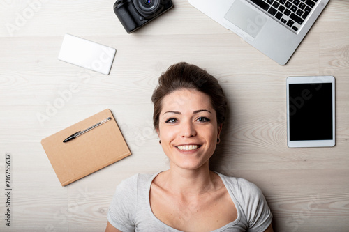 Photos Smiling happy woman surrounded by office supplies