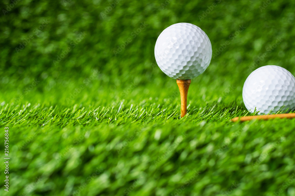 Golf ball with green grass background, on tee closeup. Golf ball with green grass background, on tee closeup.