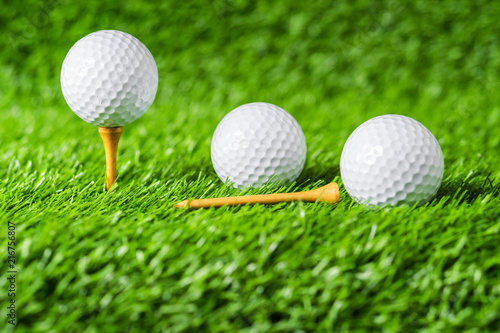 Golf ball with green grass background, on tee closeup.