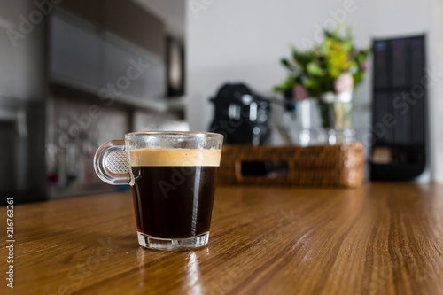 empty espresso coffee cup on kitchen counter with interesting perspective, with cup in focus and blurred background