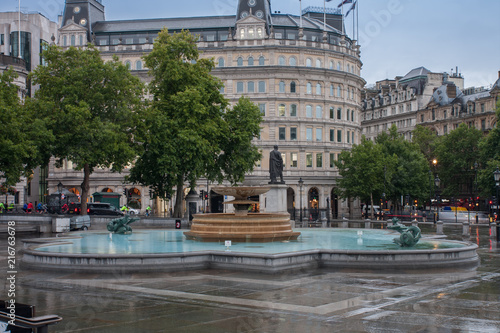 Fototapeta The fountain on Trafalgar square in rainy early morning time  in London, United